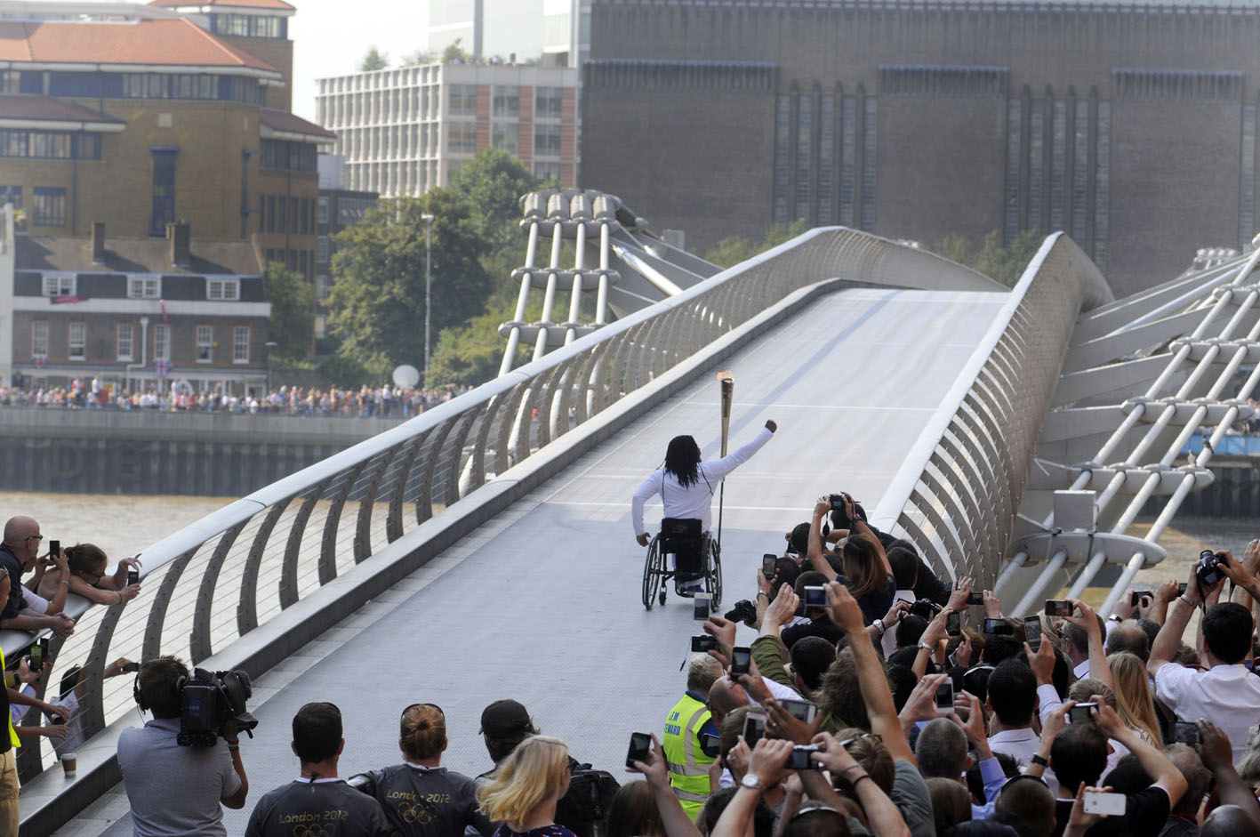 Enthusiastic crowds greet the Olympic Torch Relay as a new torch bearer  sets off across the Millennium Bridge across the River Thames to south London. On the other side another huge crowd can be seen waiting to greet him.Â© Stefano Cagnoni - reportdigital.co.uk01789 262151 07831 121483info@reportdigital.co.ukwww.reportdigital.co.ukNUJ recommended terms & conditions apply. Moral rights asserted under Copyright Designs & Patents Act 1988. No part of this photo to be stored, reproduced, manipulated or transmitted by any means without permission.